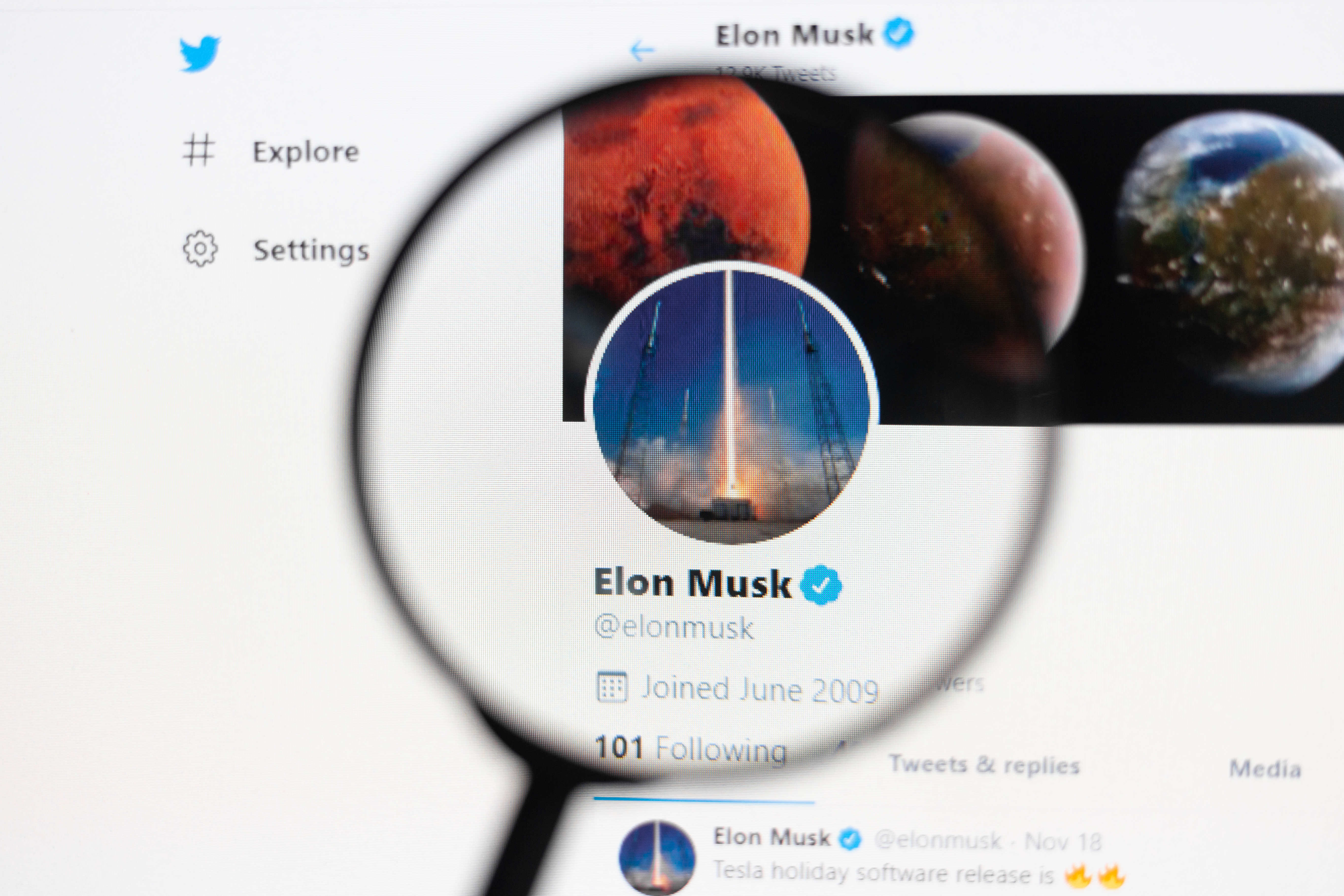 Odessa, Ukraine - December 17, 2020: Elon Mask Official twitter web page on screen through magnifying glass
